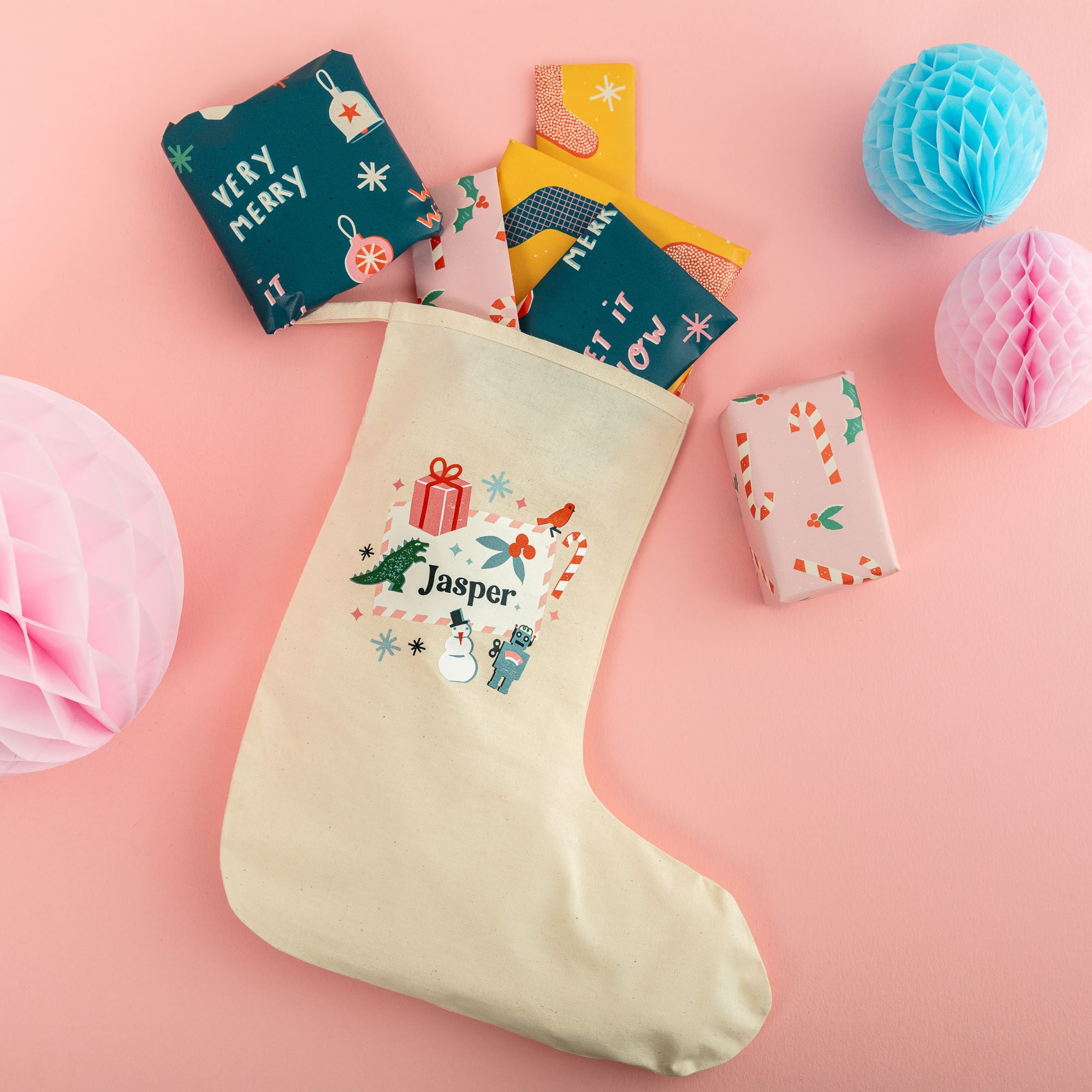 a cream stocking personalised with a name and fun festive design, surrounded by colourful presents spilling out